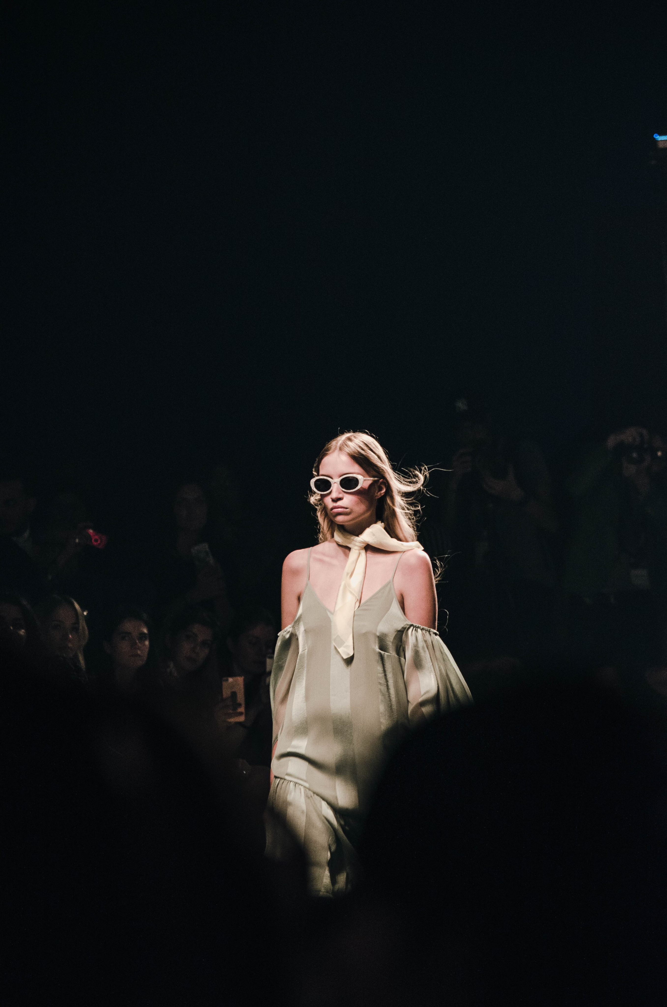 Woman with sunglasses walking down runway